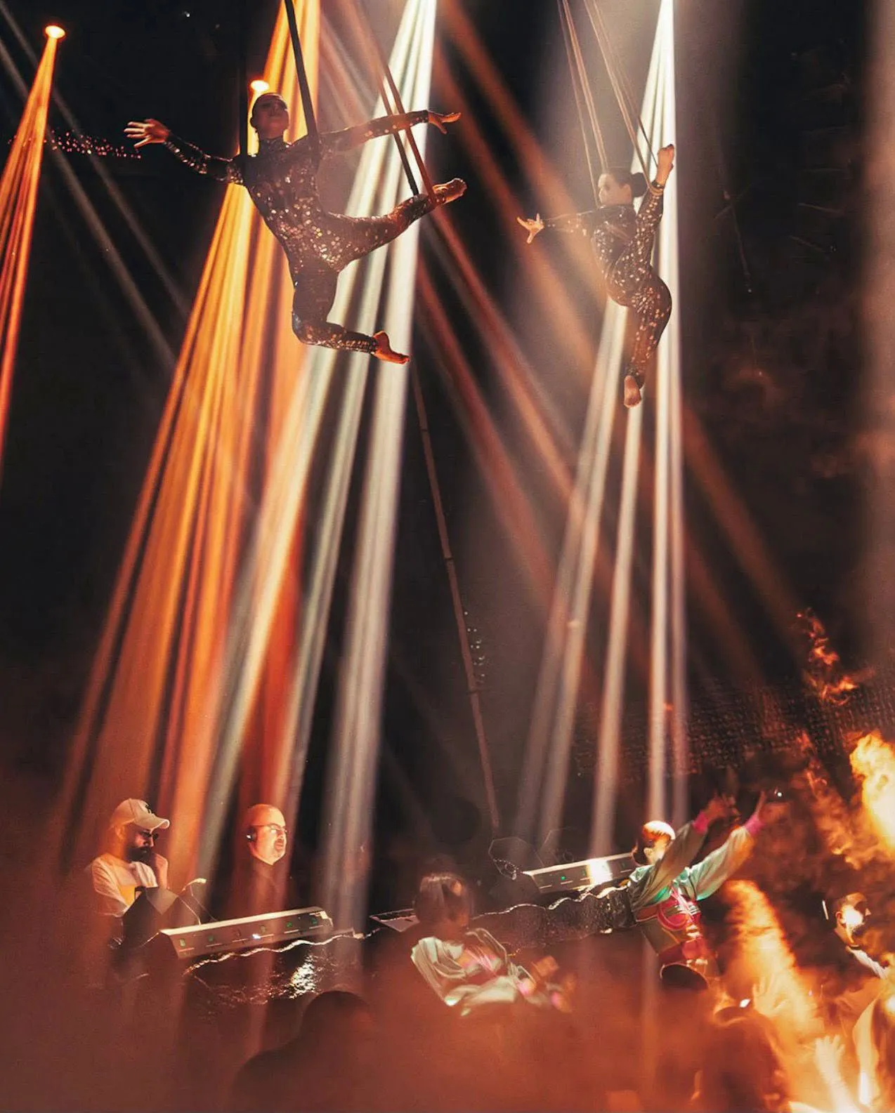Aerial acrobats performing suspended from the venue ceiling during a live stage show