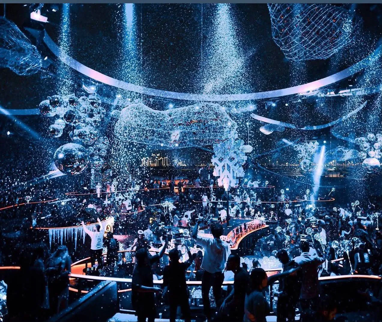 Faux snow falling over the nightlife crowd from overhead effect machines