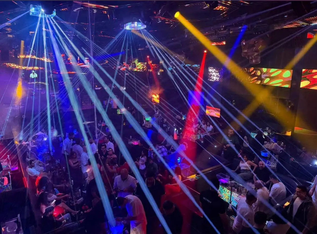 Green laser beams sweeping across partygoers gathered on the dance floor