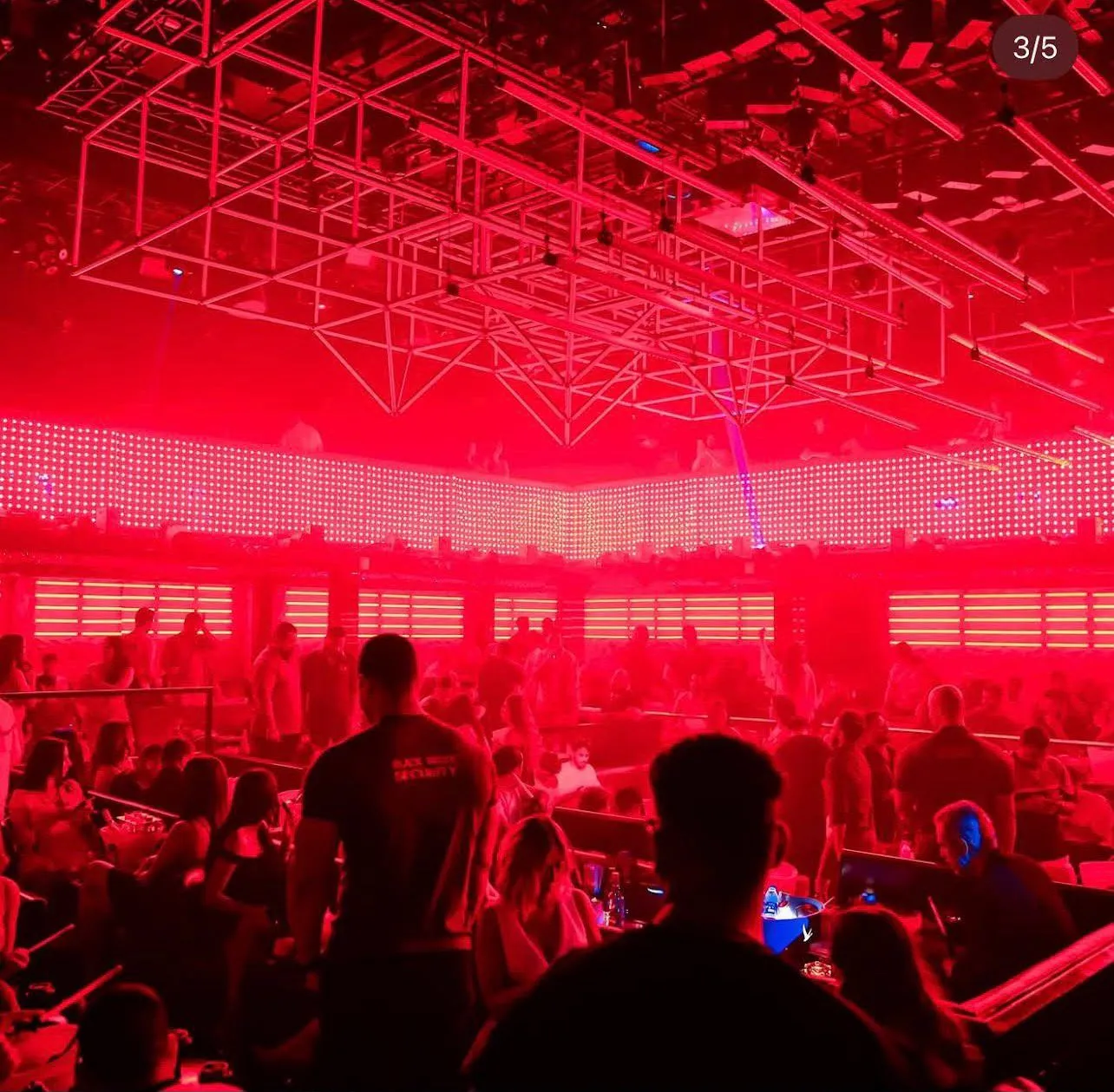 Guests dancing before a massive illuminated red digital graphic backdrop
