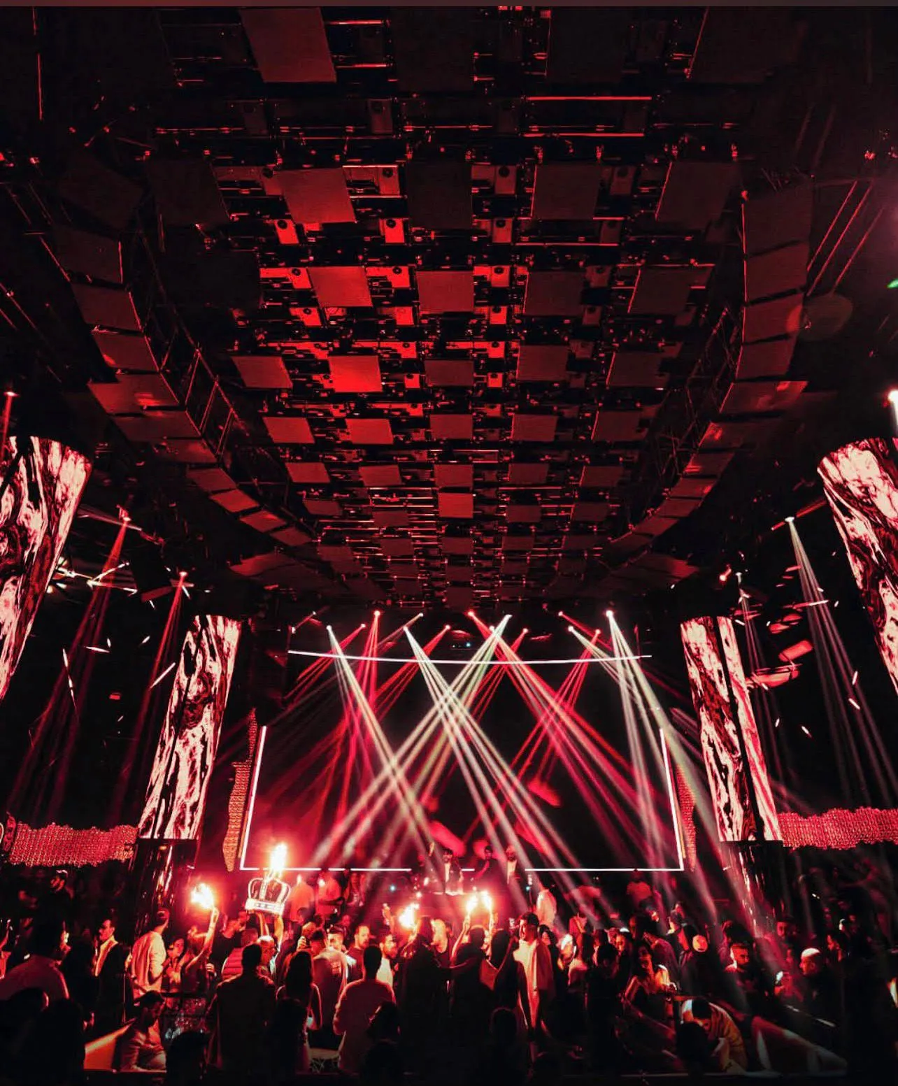 Main stage bathed in deep red stage lighting with audio equipment on display