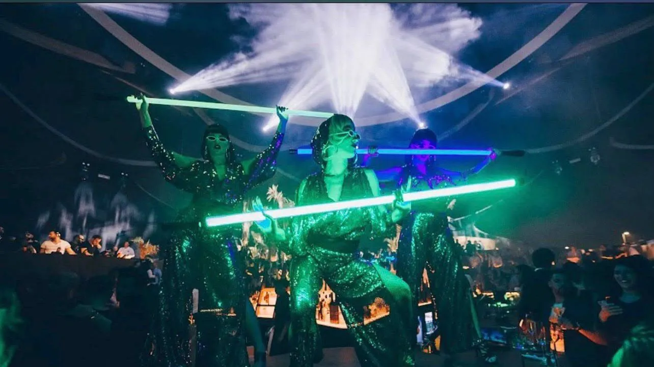 Performers wearing lighted costumes dancing on the center entertainment stage