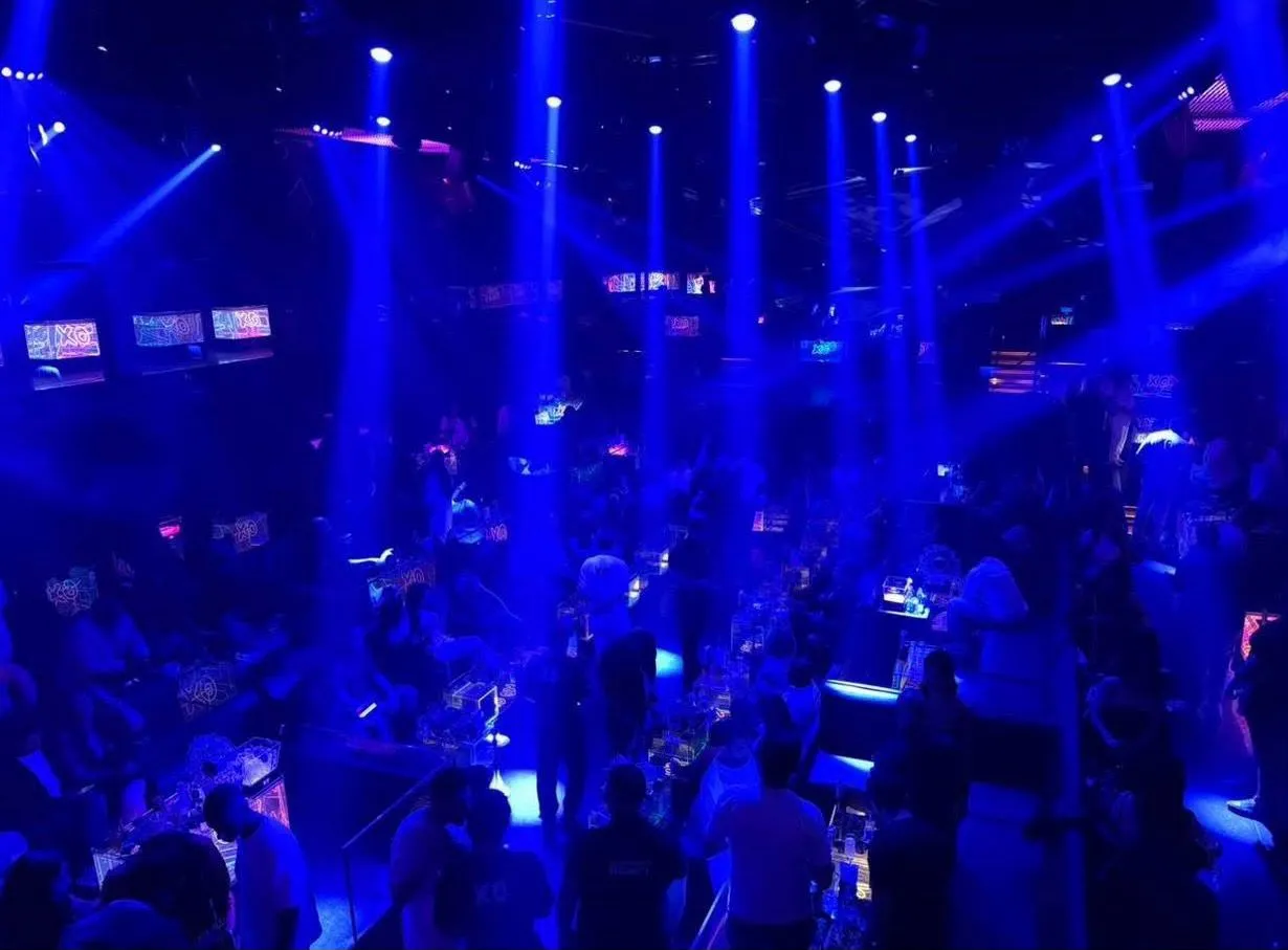 Reserved VIP booth seating illuminated by ambient blue neon fixtures at XO