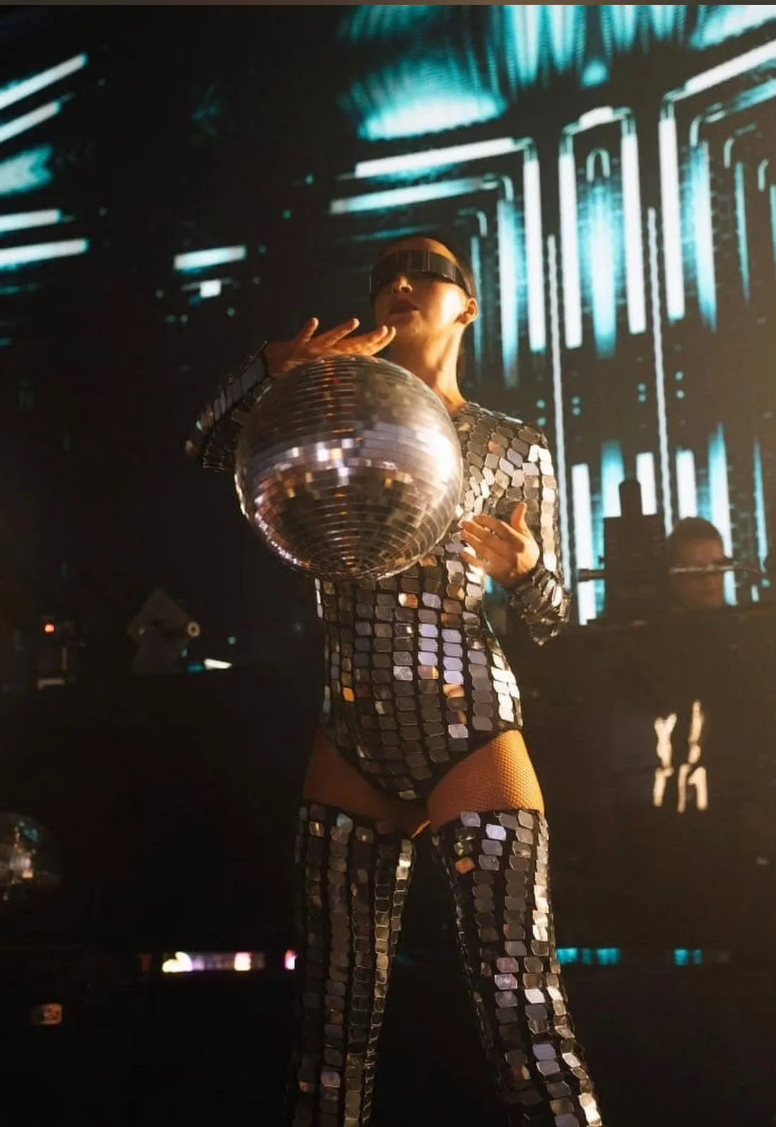 Stage performer in a glittering costume under ambient overhead illumination