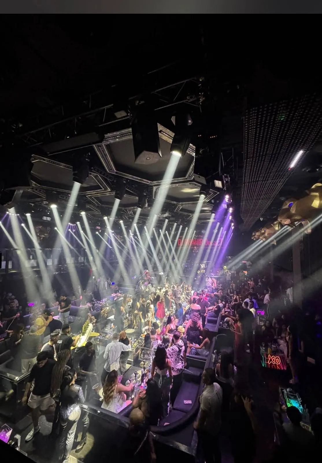 Tiered VIP tables and leather booths surrounding a spacious central dance area